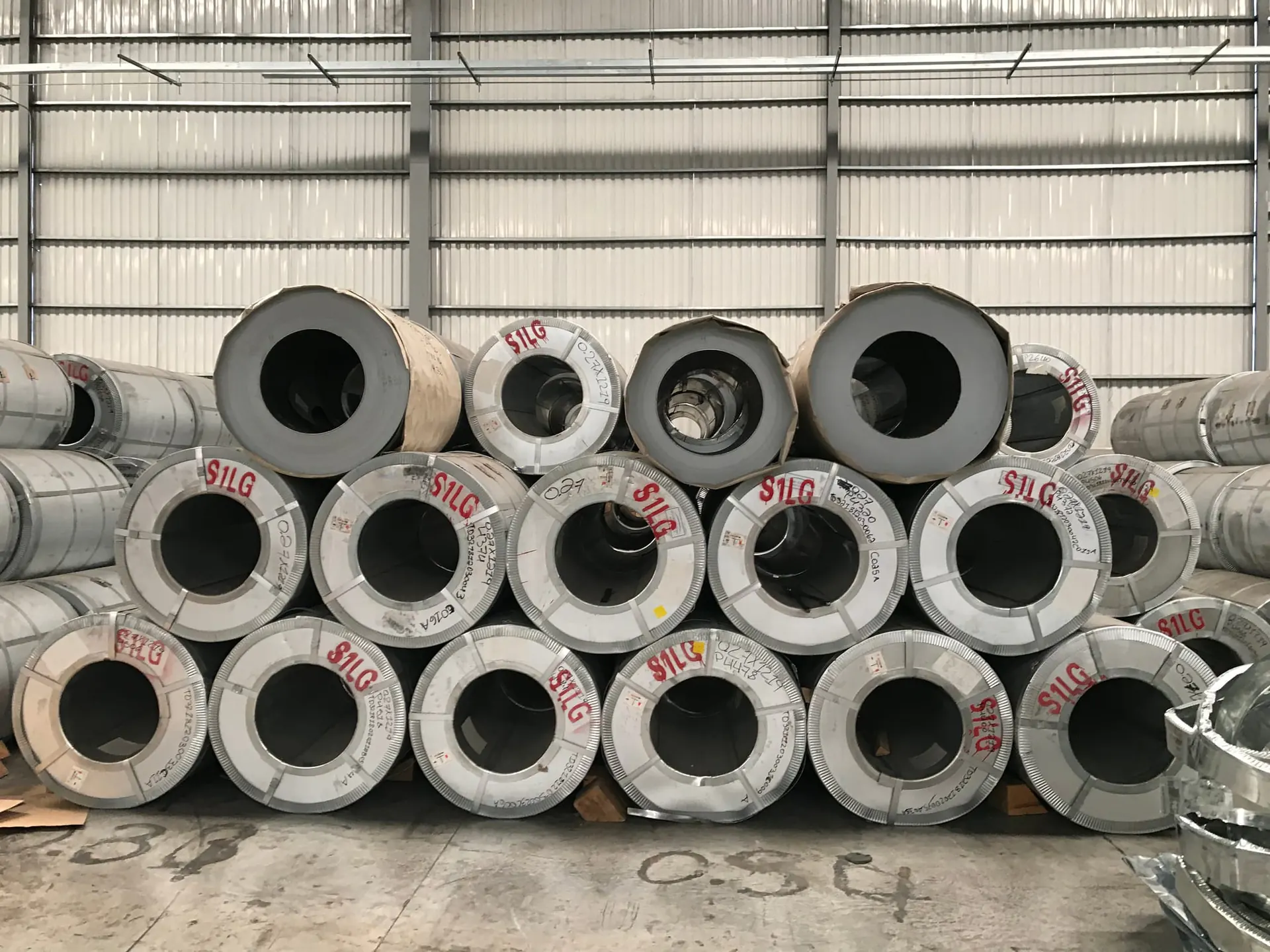 Stacked galvanised steel coils in a stockyard