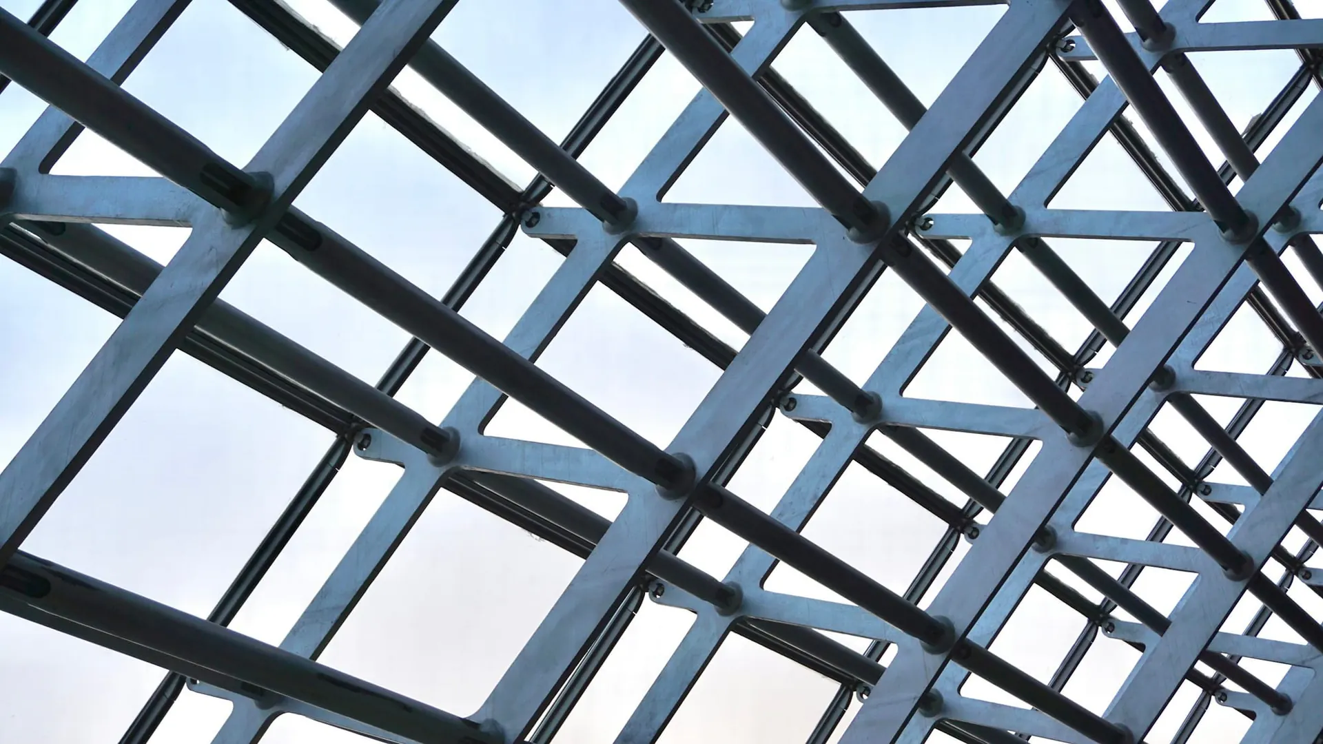 Steel structural grid against a pale sky