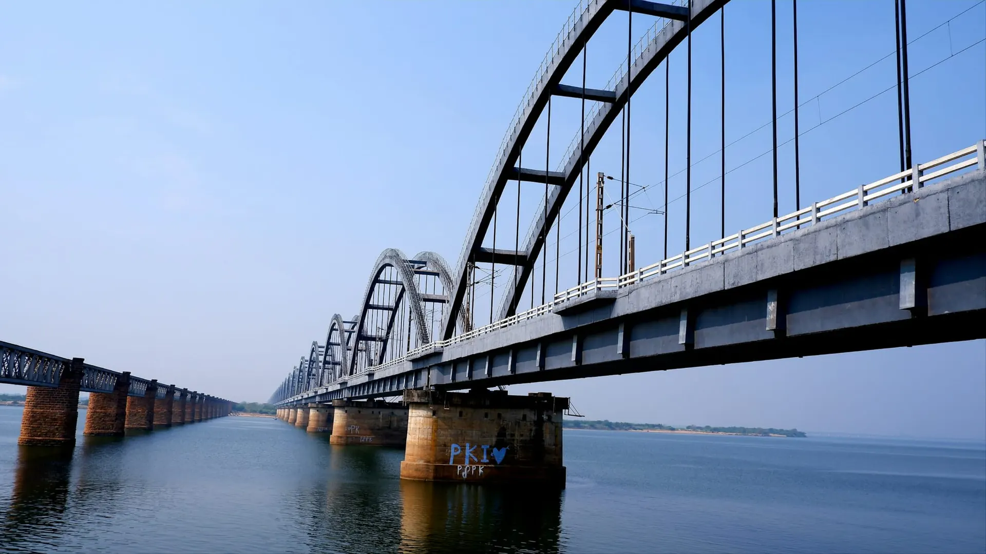 Steel arch railway bridge spanning a wide river in India