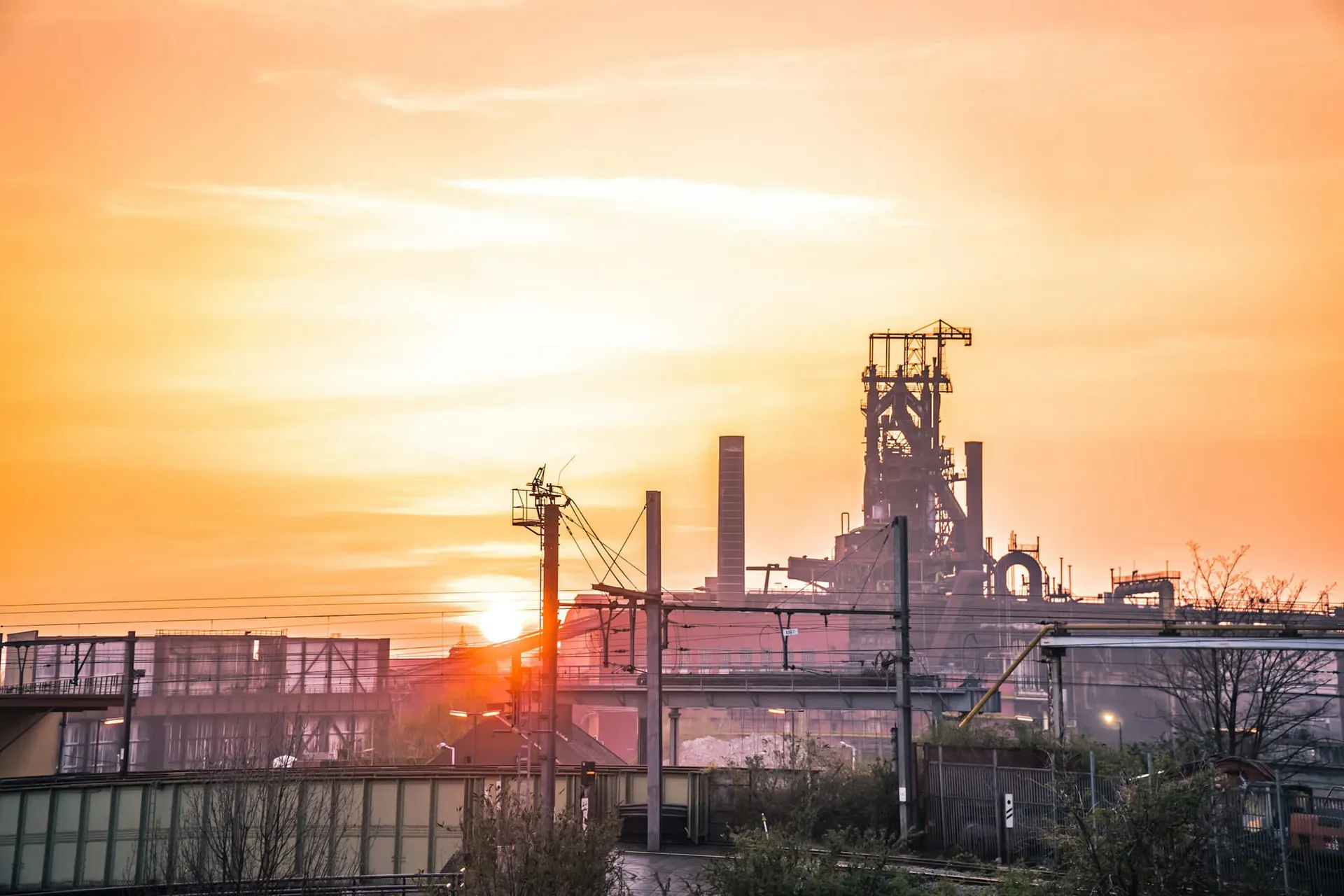Steel plant silhouetted against a golden sunrise