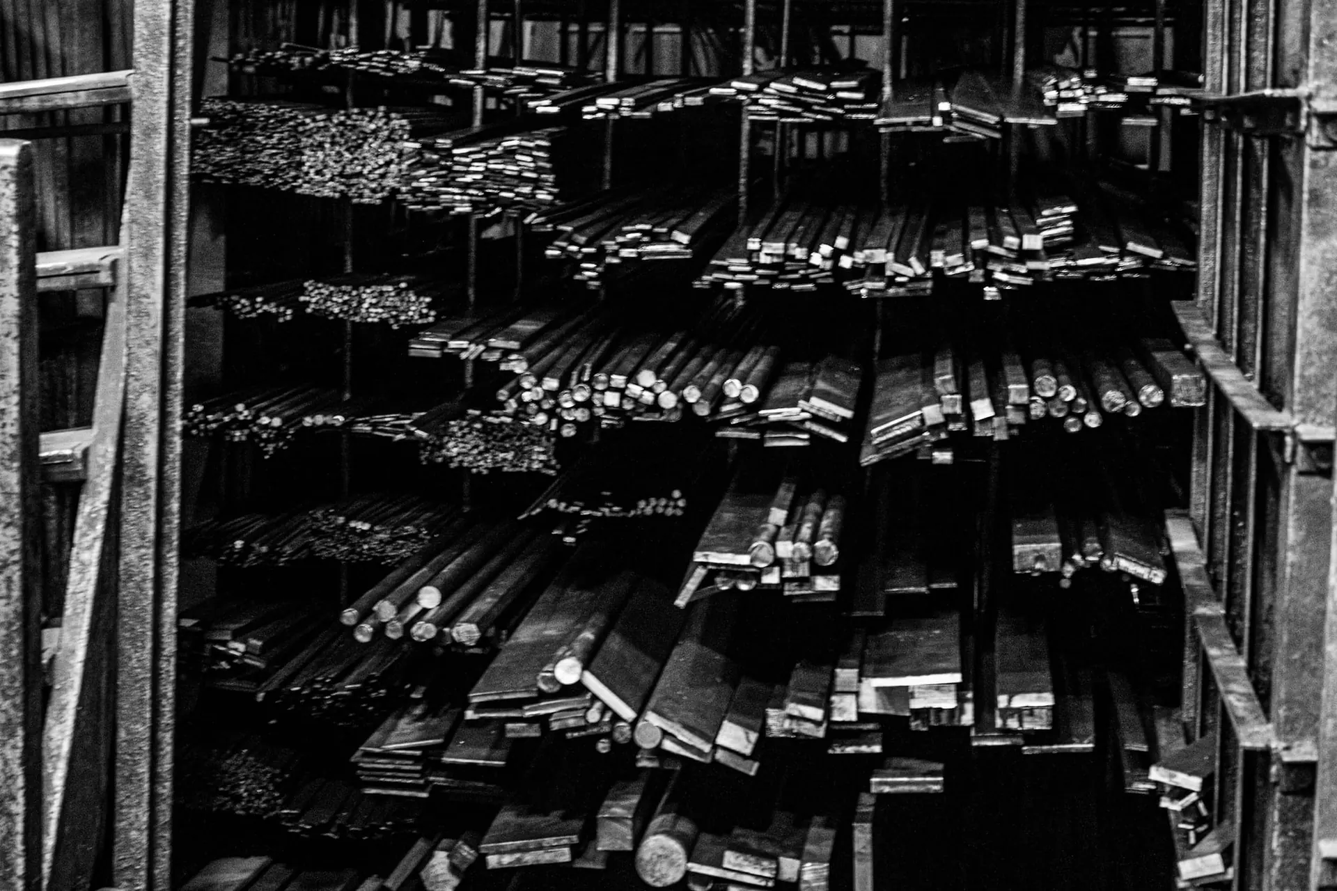Steel bars and sections neatly stacked on warehouse racks